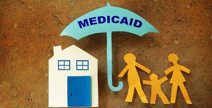 Abstract image with umbrella saying 'Medicaid' over stick figures and a house